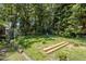 A tranquil, tree-lined backyard with a blue chair, ready for relaxation and entertainment at 4404 Susan Dr, Raleigh, NC 27603