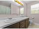 Bathroom featuring double sinks, a vanity with dark wood cabinets, and a window for natural light at 4404 Susan Dr, Raleigh, NC 27603