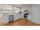 Bright kitchen with stainless steel appliances, tiled backsplash, and white cabinets and countertops at 4404 Susan Dr, Raleigh, NC 27603