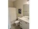 Well-lit bathroom with white cabinets, framed mirror, and decorative shower curtain at 451 N Lincoln St, Benson, NC 27504