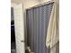 Bathroom with blue and white chevron shower curtain and open doorway at 451 N Lincoln St, Benson, NC 27504