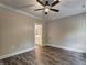 Neutral bedroom featuring ceiling fan, modern flooring, and an open doorway to the ensuite bath at 451 N Lincoln St, Benson, NC 27504