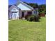 Beautiful white home features a green lawn, a two-car garage, and tasteful landscaping at 451 N Lincoln St, Benson, NC 27504