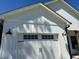 Close-up of garage door details with black farmhouse lights on either side at 451 N Lincoln St, Benson, NC 27504