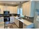 Well-lit kitchen features stainless steel appliances, white cabinets, and stylish gray backsplash at 451 N Lincoln St, Benson, NC 27504