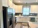 Spacious kitchen features stainless steel refrigerator, white cabinets, and modern gray backsplash at 451 N Lincoln St, Benson, NC 27504