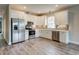 Modern kitchen with stainless steel appliances, white cabinets, gray backsplash, and durable floors at 451 N Lincoln St, Benson, NC 27504