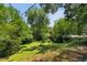 View of the landscaped and tree-lined backyard, an expansive space for outdoor activities at 503 Tarleton Ave, Burlington, NC 27215