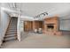 Unfinished basement with carpeted stairs, brick fireplace, and drum set at 503 Tarleton Ave, Burlington, NC 27215