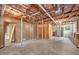 Unfinished basement with exposed insulation, wood paneling, concrete flooring, and a door leading outside at 503 Tarleton Ave, Burlington, NC 27215