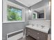 Charming bathroom features double sinks, stylish fixtures, and a large window showcasing the outdoor greenery at 503 Tarleton Ave, Burlington, NC 27215