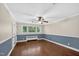 Spacious bedroom featuring two-tone walls, hardwood floors, and large window views of the surrounding landscape at 503 Tarleton Ave, Burlington, NC 27215