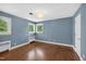 Bright bedroom features hardwood floors, blue walls, two large windows letting in natural light, and a modern light fixture at 503 Tarleton Ave, Burlington, NC 27215