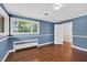 Bright blue bedroom with hardwood floors and natural light at 503 Tarleton Ave, Burlington, NC 27215