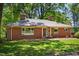 Attractive red brick home with mature trees, beautiful lawn, and ample natural light, creating a welcoming exterior at 503 Tarleton Ave, Burlington, NC 27215