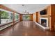 Expansive living room features hardwood floors, wood paneling, a fireplace, and numerous windows offering abundant natural light at 503 Tarleton Ave, Burlington, NC 27215