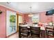 Dining room featuring pink walls, light fixture, table with chairs, curtains and glass door to the outside at 506 Currin St, Durham, NC 27703