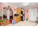 Kitchen area featuring pink walls, wooden cabinets, tile floors, and a view of the living room and hallway at 506 Currin St, Durham, NC 27703