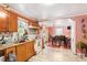 Kitchen area with tile floors, pink walls, wooden cabinets, modern appliances and a view of the dining room at 506 Currin St, Durham, NC 27703