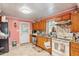 Kitchen featuring pink walls, a tile backsplash, wooden cabinets, modern appliances, tile floors and a door at 506 Currin St, Durham, NC 27703