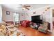 View of living room showing hardwood floors, ceiling fan, red sofa, and television at 506 Currin St, Durham, NC 27703