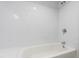 Bright white tiled bathroom with shower and bath with white bathtub at 5123 Richland Dr, Raleigh, NC 27612