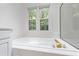 Bathroom featuring a soaking tub, and a bright window with backyard views at 5123 Richland Dr, Raleigh, NC 27612
