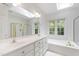 Bright bathroom with skylights, double sinks, soaking tub and shower with gold hardware at 5123 Richland Dr, Raleigh, NC 27612