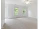 Spacious bedroom featuring carpeted floors, white trim, and sun-filled windows offering backyard views at 5123 Richland Dr, Raleigh, NC 27612