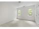 Bright bedroom featuring a ceiling light, neutral carpet, and natural light from two windows at 5123 Richland Dr, Raleigh, NC 27612