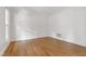 Bright bedroom with hardwood floors, white walls, and a large window at 5123 Richland Dr, Raleigh, NC 27612