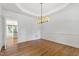 Bright dining room with hardwood floors, crown molding, recessed lights and a contemporary chandelier at 5123 Richland Dr, Raleigh, NC 27612