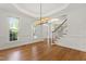 Spacious dining room featuring hardwood floors, two windows, and modern lighting fixture at 5123 Richland Dr, Raleigh, NC 27612
