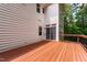 View of back of house with outdoor wooden deck overlooking wooded property at 5123 Richland Dr, Raleigh, NC 27612