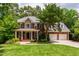 Stunning brick home with mature trees, green lawn, and a spacious driveway leading to an attached two-car garage at 5123 Richland Dr, Raleigh, NC 27612