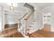 Elegant foyer with hardwood floors, a staircase with white spindles, and openings to adjacent rooms at 5123 Richland Dr, Raleigh, NC 27612