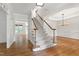 Bright foyer with hardwood floors, a staircase with white risers, and open access to other rooms at 5123 Richland Dr, Raleigh, NC 27612