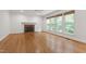 Living room with hardwood floors, fireplace, and three large windows with woven wood shades at 5123 Richland Dr, Raleigh, NC 27612