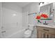 Bathroom features tile flooring, shower-tub combo and wood vanity with granite countertop at 5300 Roan Mountain Pl, Raleigh, NC 27613