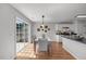 Cozy dining area with a sliding glass door and modern lighting fixture adjacent to the kitchen at 5300 Roan Mountain Pl, Raleigh, NC 27613