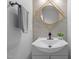 Stylish half bath with a modern vanity, decorative mirror and textured wallpaper at 5300 Roan Mountain Pl, Raleigh, NC 27613