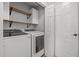 Laundry room features newer washer and dryer with additional cabinet and shelf storage at 5300 Roan Mountain Pl, Raleigh, NC 27613