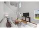 Sunlit living room showcases a staircase, high ceilings, and entertainment area creating a cozy ambiance at 5300 Roan Mountain Pl, Raleigh, NC 27613