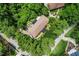 An aerial view shows a house with a large roof nestled in lush greenery at 5301 Thayer Dr, Raleigh, NC 27612