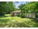 Home exterior featuring a lush green lawn with mature trees, offering a serene setting at 5301 Thayer Dr, Raleigh, NC 27612