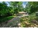 Exterior of the home featuring a long driveway leading to the property surrounded by trees at 5301 Thayer Dr, Raleigh, NC 27612