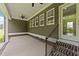 Stylish covered back porch with ceiling fan, brick accents and steps to a lush yard at 543 Allessandra Dr, Clayton, NC 27527