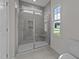 Modern bathroom features glass shower, neutral tile and a bright window at 543 Allessandra Dr, Clayton, NC 27527