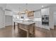 A kitchen with white cabinets, light countertops, stainless steel appliances, a large island, and pendant lighting at 543 Allessandra Dr, Clayton, NC 27527