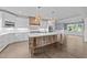 A kitchen with white cabinets, light countertops, stainless steel appliances, a large island, and pendant lighting at 543 Allessandra Dr, Clayton, NC 27527